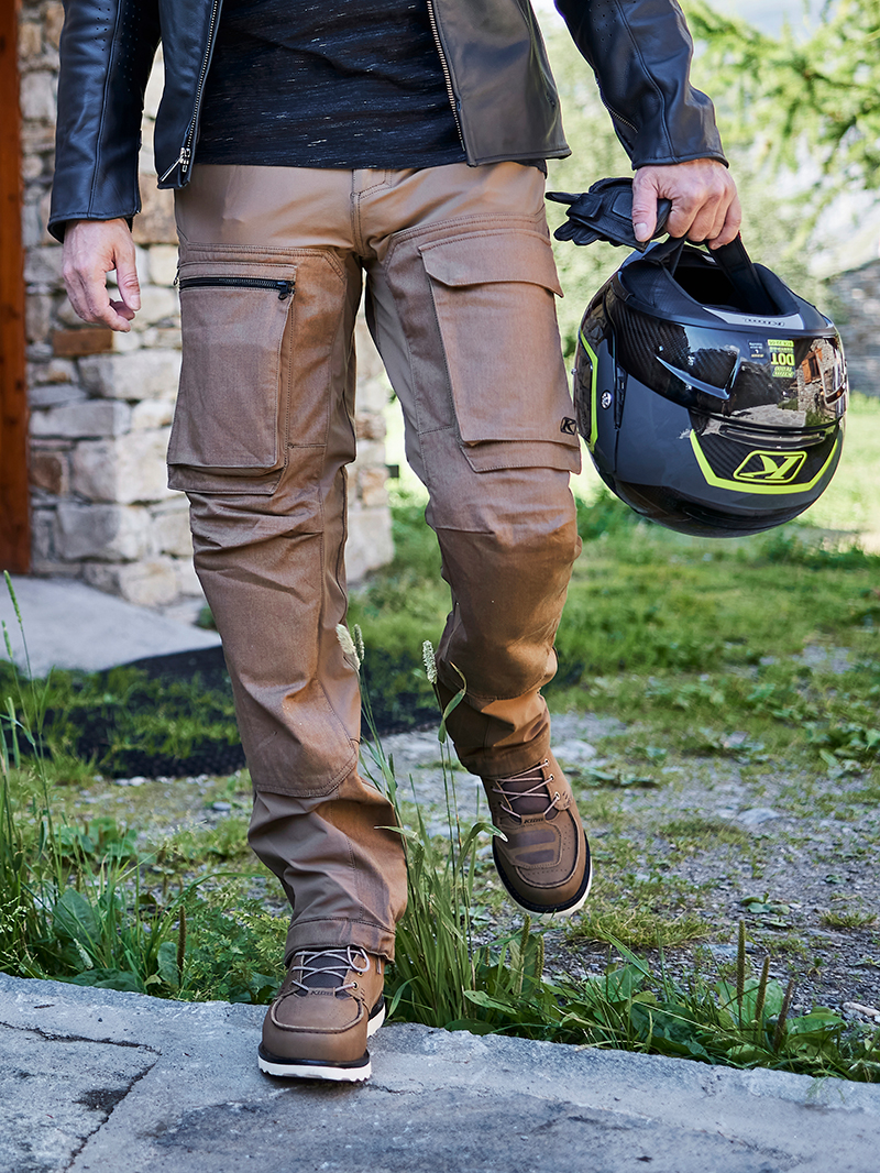 Guy wearing Klim Switchback cargo pant holding Klim helmet